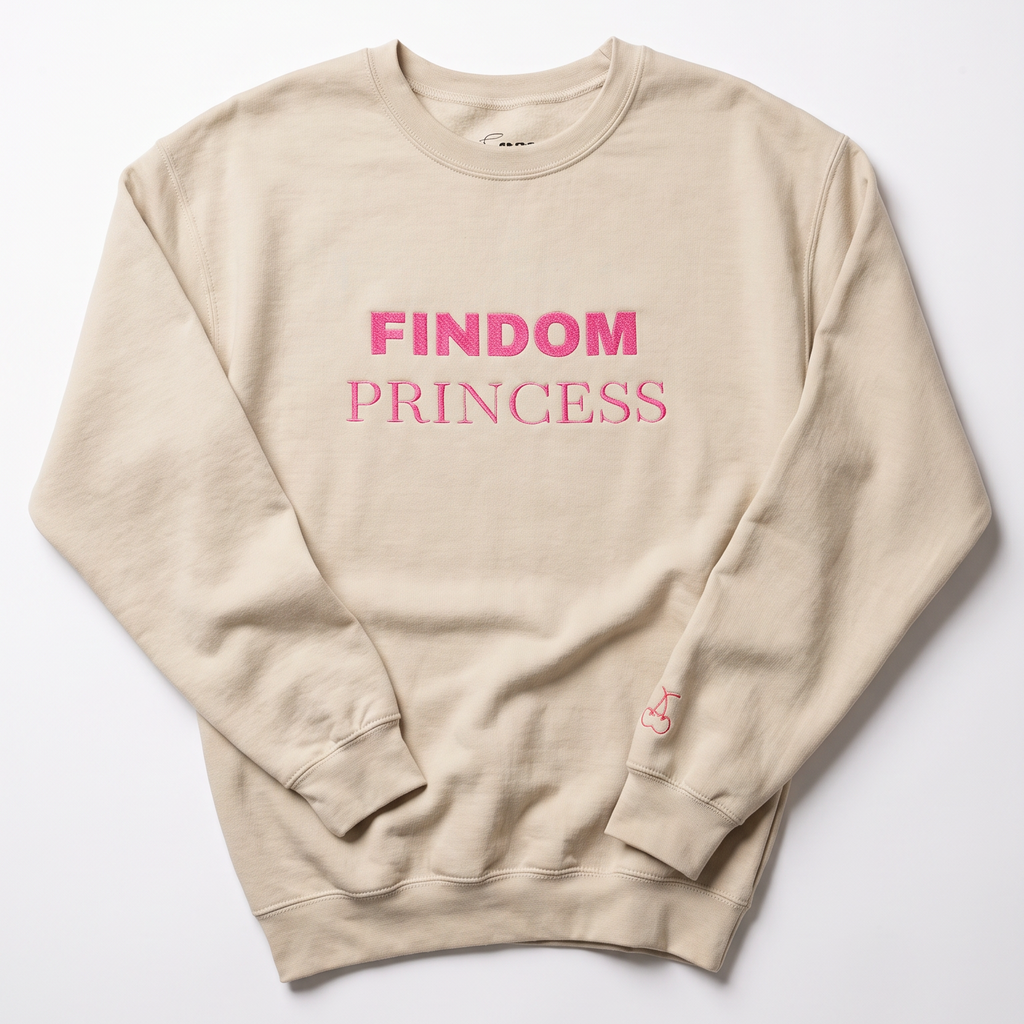 A beige crewneck sweatshirt with 'FINDOM PRINCESS' printed in pink across the chest, laid flat on a light gray background.